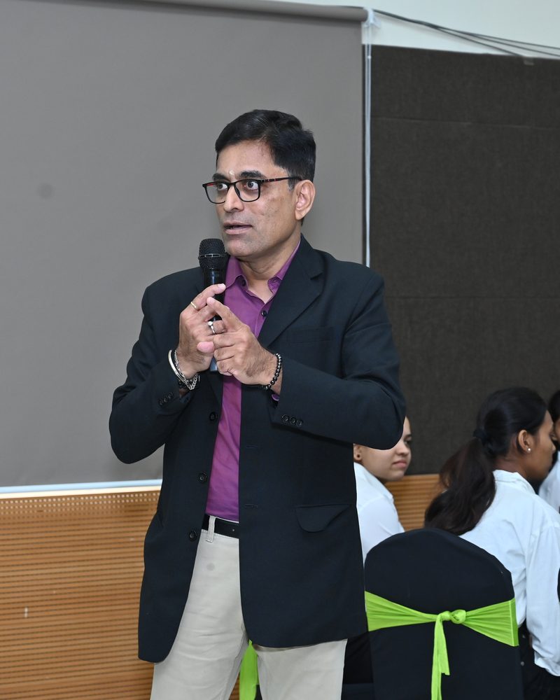 Srikanth Kalyanasundaram addressing a student audience with a microphone
